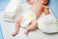 Feet of newborn baby on changing table with diapers. Cute little girl or boy two weeks old. Dry and healthy body and Royalty Free Stock Photo
