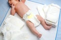 Feet of newborn baby on changing table with diapers. Cute little girl or boy two weeks old. Dry and healthy body and Royalty Free Stock Photo