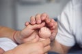 Feet of a newborn baby in parents hands. Mum and Dad hug their baby& x27;s legs. Royalty Free Stock Photo