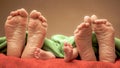 Feet of newborn baby and parents together on the bed Royalty Free Stock Photo