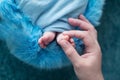 Feet of a newborn baby, toes in the hands of mom and dad, hands and nails of a child, the first days of life after birth, Royalty Free Stock Photo