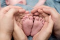 Feet of a newborn baby, toes in the hands of mom and dad, hands and nails of a child, the first days of life after birth,