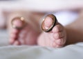 Baby wearing wedding rings on big toes Royalty Free Stock Photo