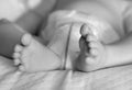 Feet of a one months old baby wearing diapers lying in bed Royalty Free Stock Photo