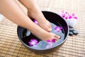 Feet in oriental foot bath with flowers Royalty Free Stock Photo