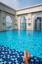 Feet over the sparkling pool on top of building with Saigon aerial view Royalty Free Stock Photo