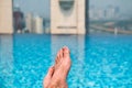 Feet over the sparkling pool on top of building with Saigon aerial view Royalty Free Stock Photo