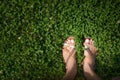 Feet with painted light pink nails in grass Royalty Free Stock Photo