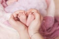 The feet in the palms, the mother holds the feet of her newborn child in her hands Royalty Free Stock Photo