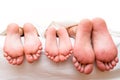 Feet of parents and child on the bed Royalty Free Stock Photo