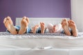 Feet of parents and children lying on the bed Royalty Free Stock Photo