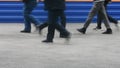 feet of passers-by against the background of a train at the station