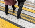 Feet of people at a pedestrian crossing in winter