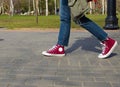 Feet of people walking in sports shoes down the street on a sunny day Royalty Free Stock Photo