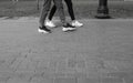 Feet of people walking in sports shoes down the street on a sunny day Royalty Free Stock Photo