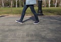 Feet of people walking in sports shoes down the street on a sunny day Royalty Free Stock Photo