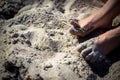 Feet of a person covered in sand on a beach