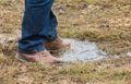 Feet of a person standing in a puddle of water