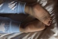 feet of preschool baby boy on blue pajama lying on white bed at home. plump legs of sleeping 3 year old caucasian child