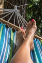 Feet with red-painted nails in a hammock