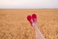 Feet in red shoes funny sticking out of wheat field. be yourself