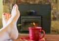 Feet Resting by the Fire With a Cup of Tea Royalty Free Stock Photo