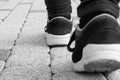 Feet in running shoes are walking forward on stony road. Royalty Free Stock Photo
