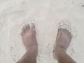 An African man standing with toes in sand on the beach. Royalty Free Stock Photo