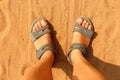 Feet in sandals on orange sand Royalty Free Stock Photo