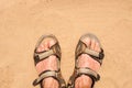 Feet in sandals on sand Royalty Free Stock Photo