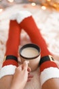 Feet in Santa`s socks near the Christmas tree