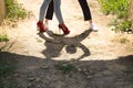 Feet and shadow of a young couple dancing sensual bachata under an ancient stone arch in an outdoor park. Latin, sensual,