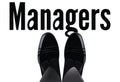 Feet with shiny shoes above written manager-