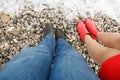 Feet in shoes on pebbles of sea shore. cold spring coast. journey to water Royalty Free Stock Photo