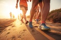 Feet in shoes, running athletes on the beach along the sea at sunset.