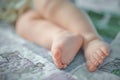 Feet of a six months old baby wearing diapers lying on the bed at home Royalty Free Stock Photo