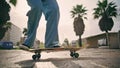 Feet skateboarder performing trick with longboard at summer sunlight outdoors. Royalty Free Stock Photo