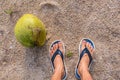 Feet slippers and coconut on the beach