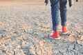 Feet sneaker on crack dry ground Royalty Free Stock Photo