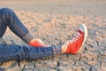 Feet sneaker on crack dry ground Royalty Free Stock Photo