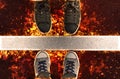 Feet in sneakers, standing next to white street lines in flame.