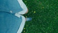 Feet in sneakers walking on green grass in firld POV ot top view vertical