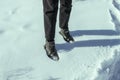 Feet in the snow. Women`s feet in boots stand in the snow.