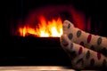 Feet in socks of all the family warming by cozy fire