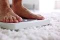 Feet standing on bathroom scale