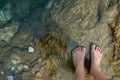 feet standing by the edge of a clear, bubbling spring Royalty Free Stock Photo