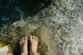 feet standing by the edge of a clear, bubbling spring Royalty Free Stock Photo