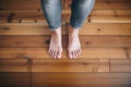 feet standing on a smooth wooden plank floor