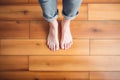 feet standing on a smooth wooden plank floor