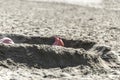 Feet sticking out of a sand pit